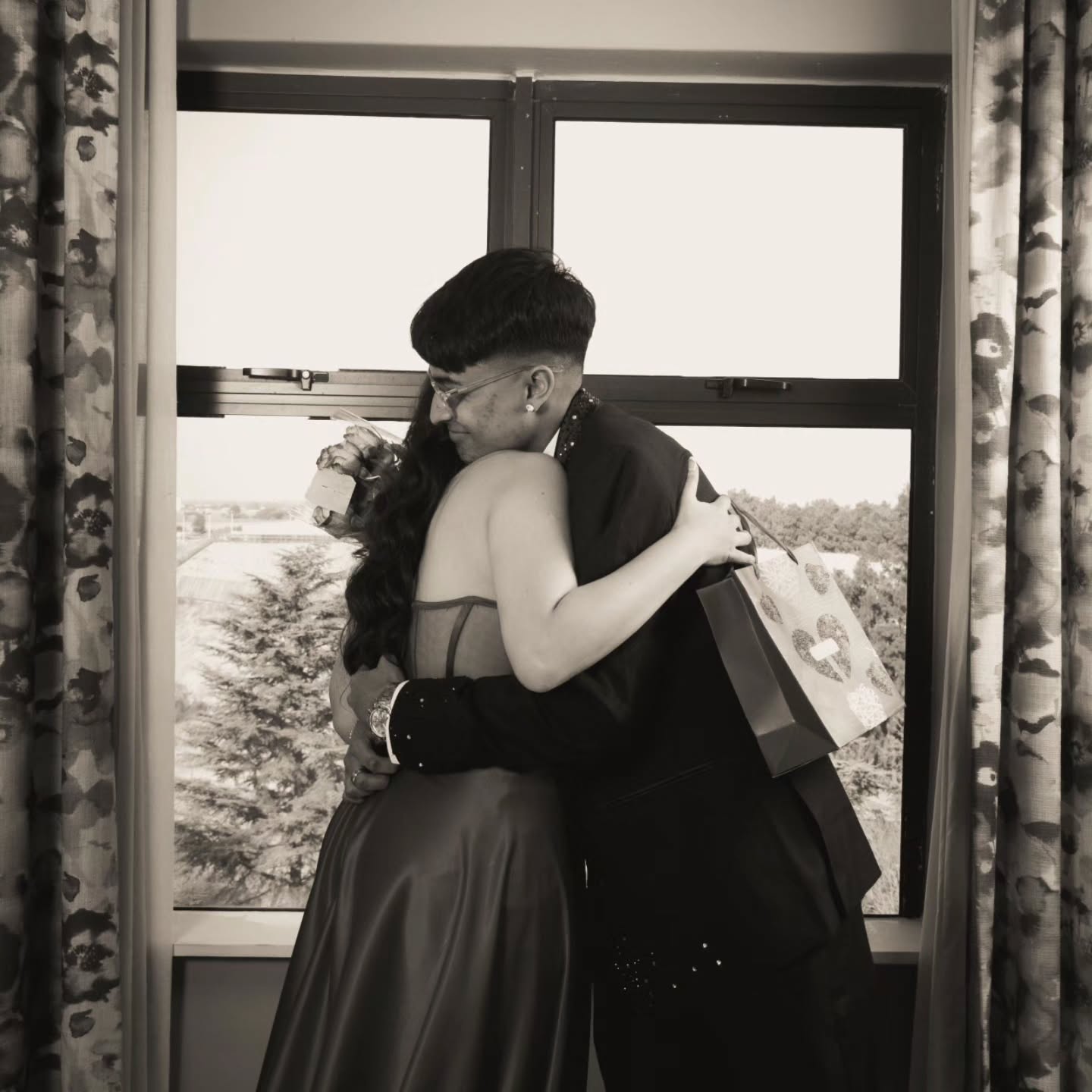 Black and white couple portrait: embrace in front of a window